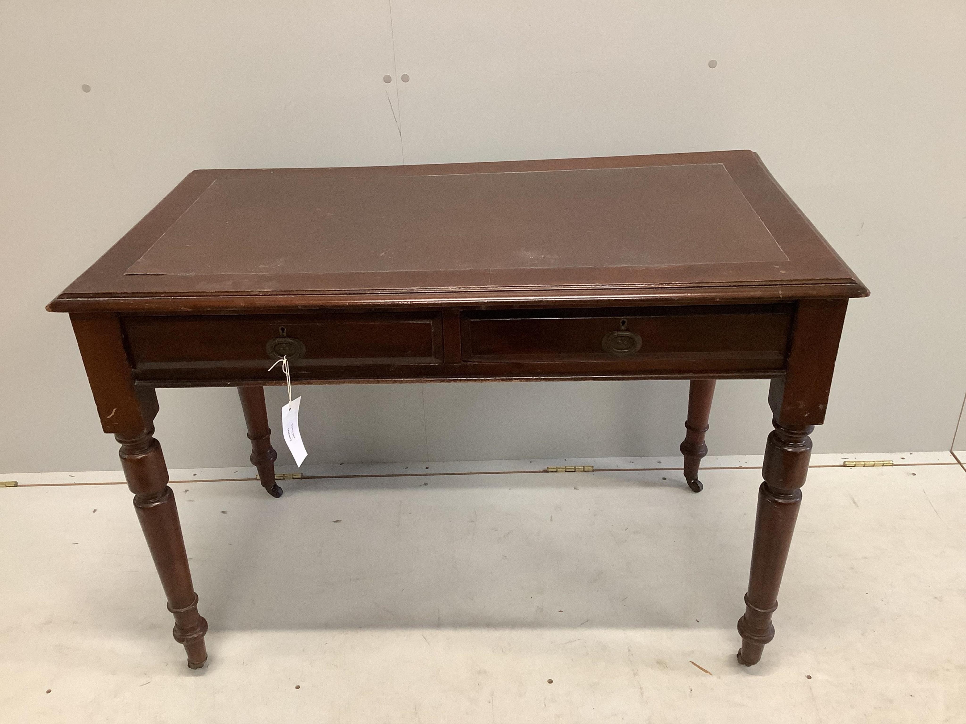 An early 20th century mahogany writing table with two frieze drawers with brass ring handles on turned legs and castors, width 106cm, depth 59cm, height 75cm. Condition - fair